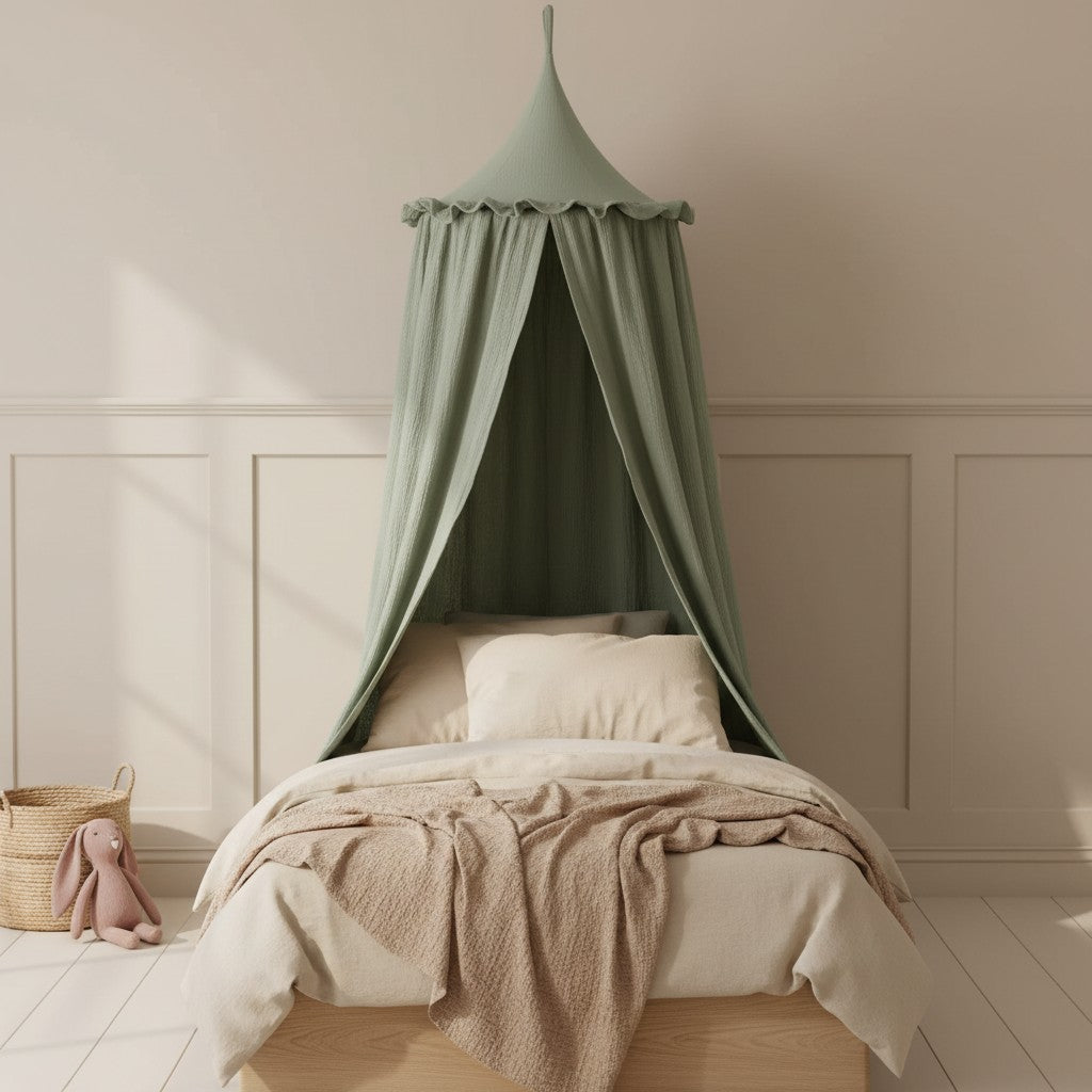 A light sage green canopy bed netting draped over a wooden bed frame in a softly lit nursery with beige bedding, white wainscoting, and a plush bunny toy on the floor.