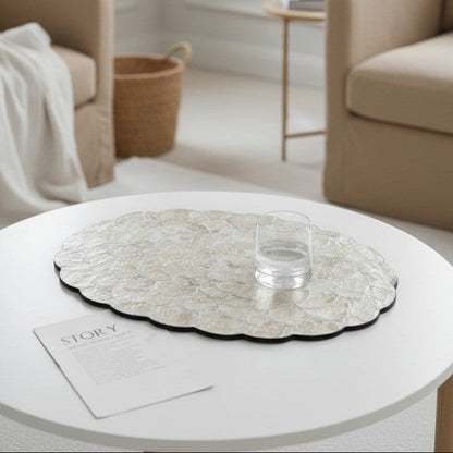 Modern living room with beige armchairs, a round coffee table, and decorative items.
