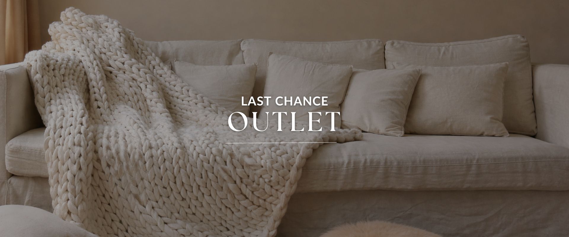 Beige blanket draped over a sofa with 'Last Chance Outlet' text overlay.