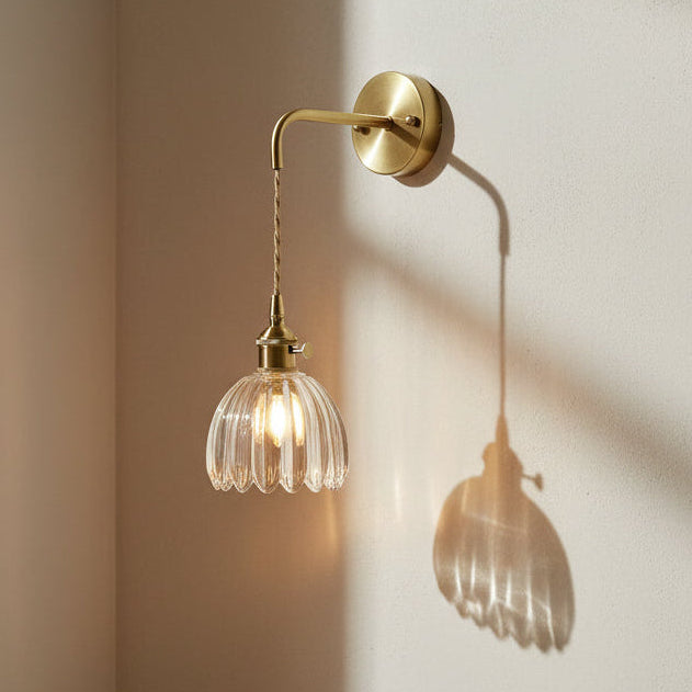 Wall-mounted lamp with glass shade in a cozy room setting.