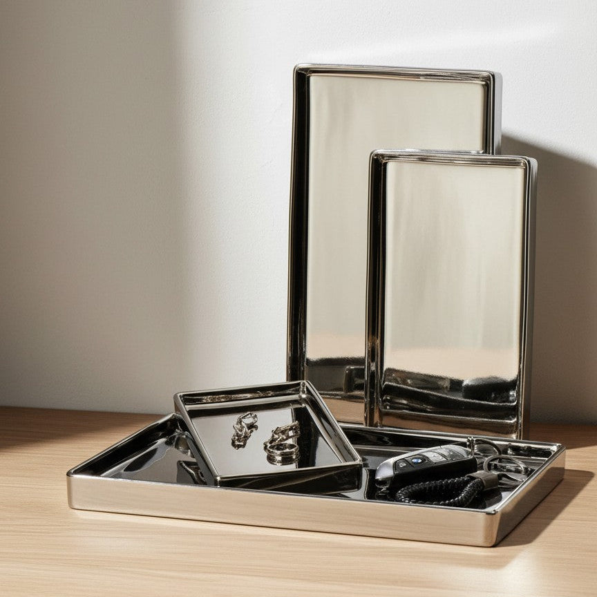 Set of metallic trays on a wooden surface with a neutral background