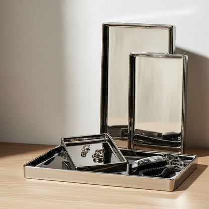 Set of metallic trays on a wooden surface with a neutral background