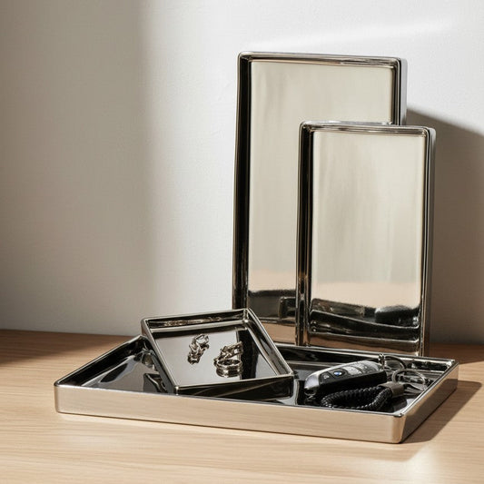 Set of metallic trays on a wooden surface with a neutral background