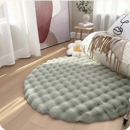 Round green rug on a wooden floor with a white bed and decorative items in the background.