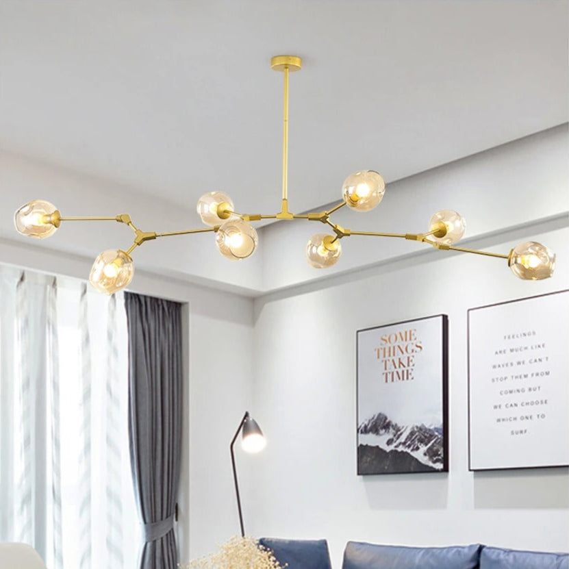 Modern living room with a gold chandelier, blue sofa, and decorative elements.